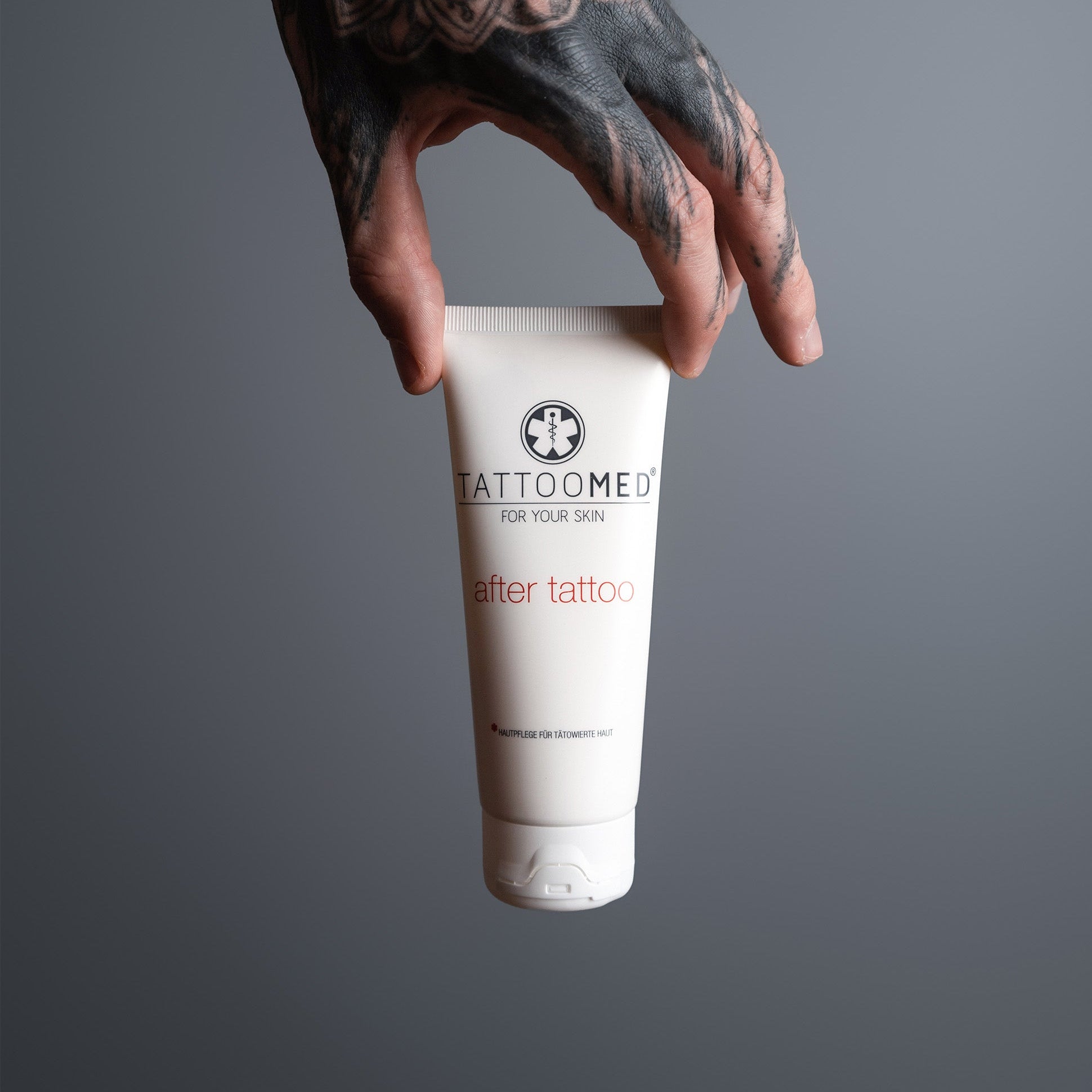 Tätowierte Hand hält TattooMed After Tattoo