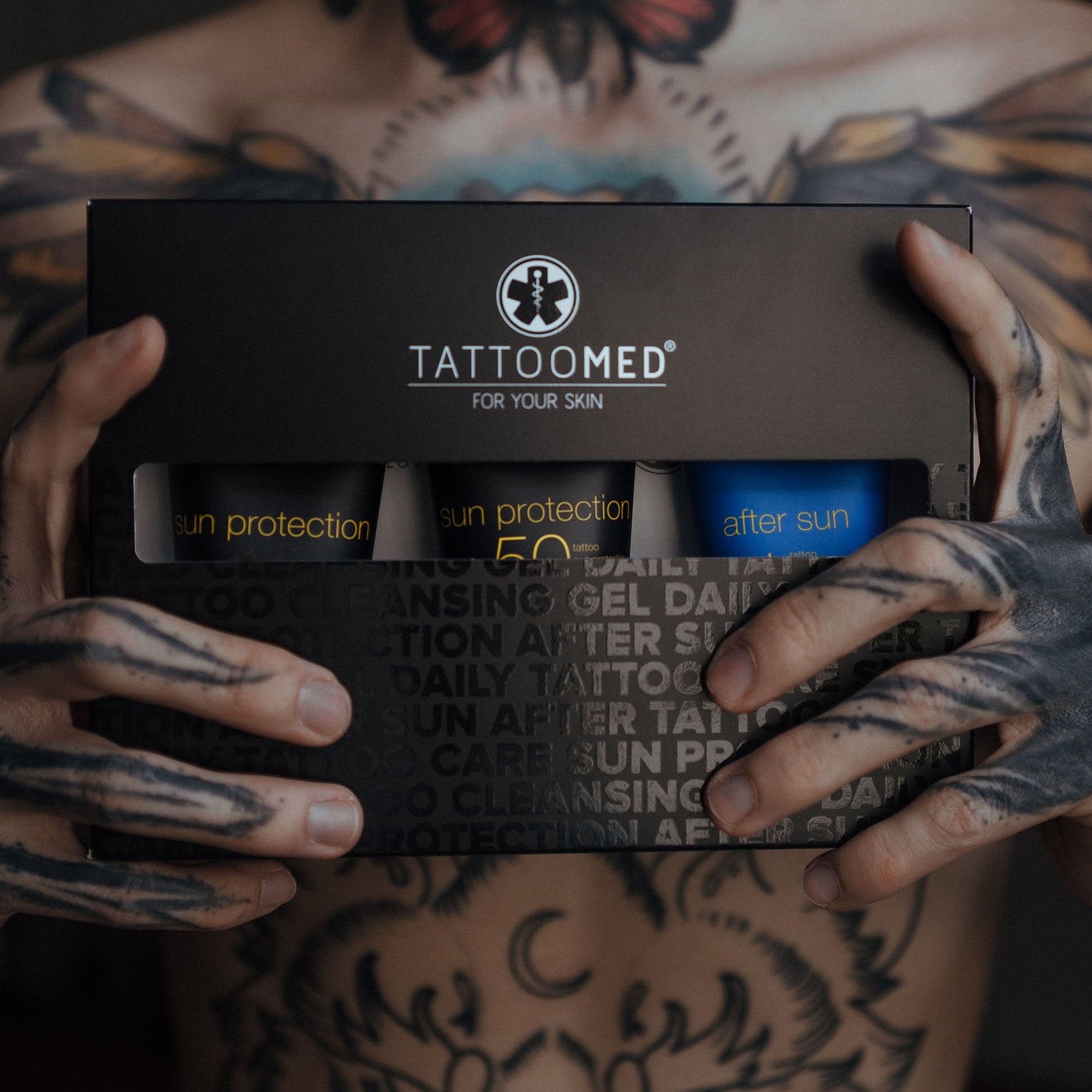 TattooMed All In Bundle Sun gehalten von einer tätowierten Person