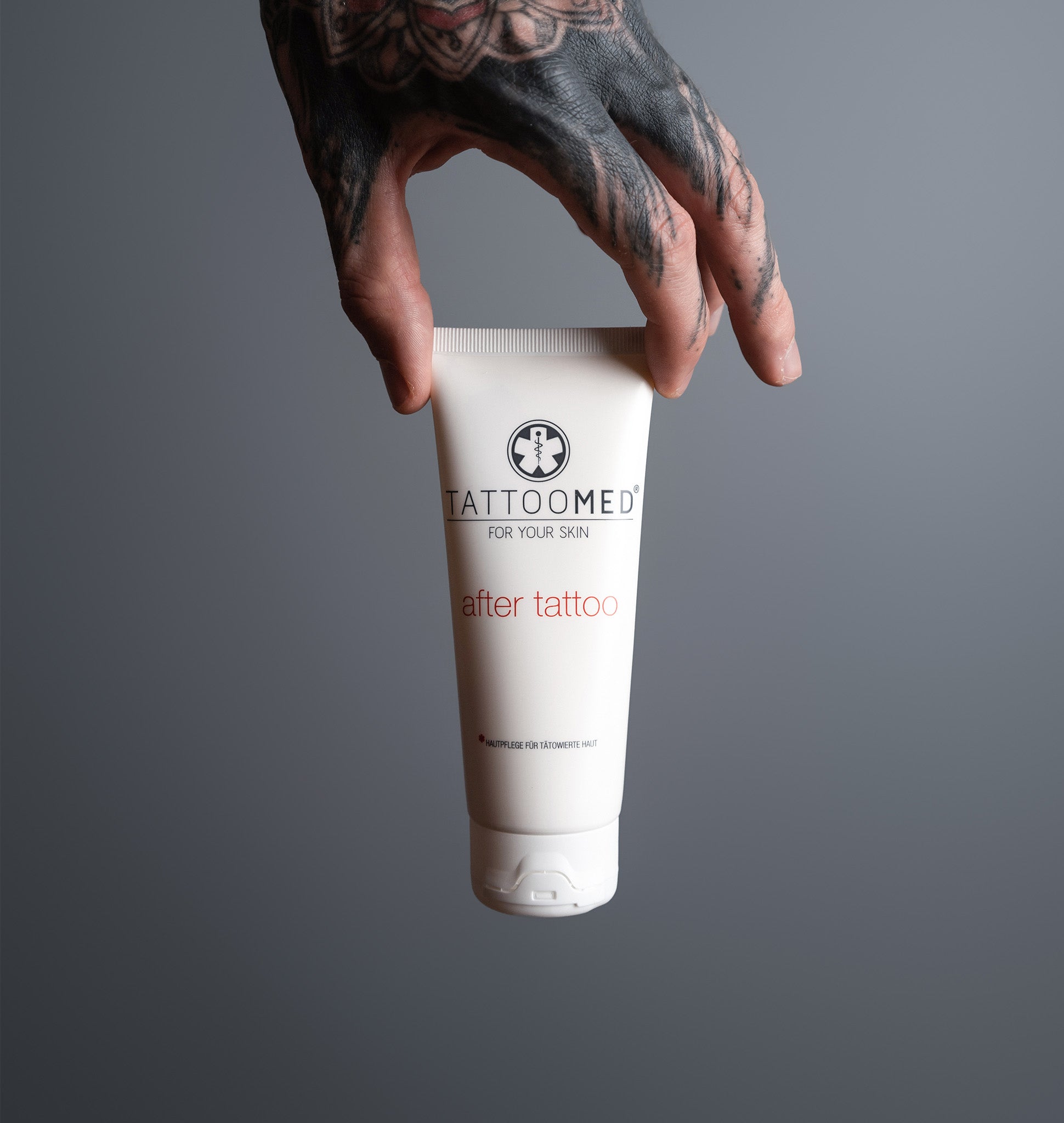 Tätowierte Hand hält TattooMed After Tattoo