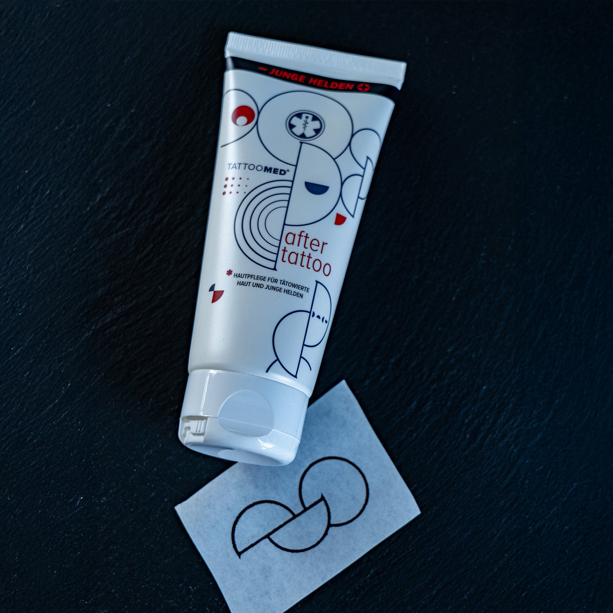 TattooMed® After Tattoo x Junge Helden Special Edition liegend neben einem Tattoo Stencil mit Organspende Tattoo