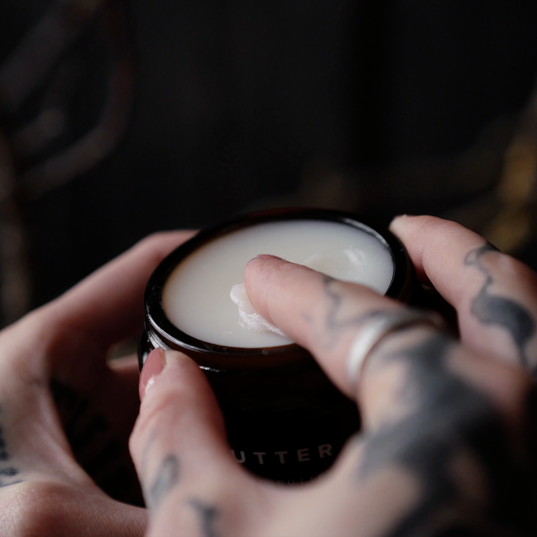 TattooMed Tattoo Butter wird von einer tätowierten Hand aufgetragen