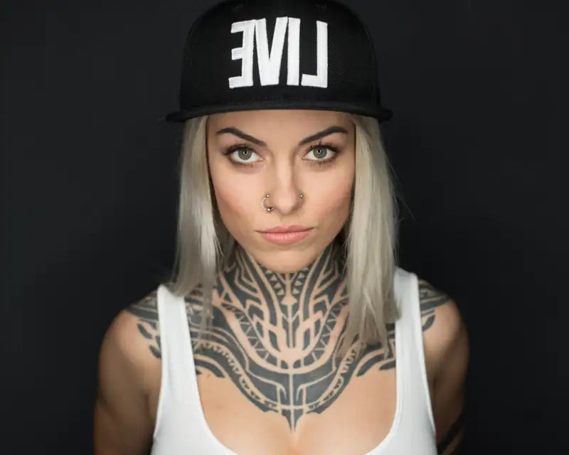 Tätowiererin mit Tribal-Tattoo an Hals und Brust